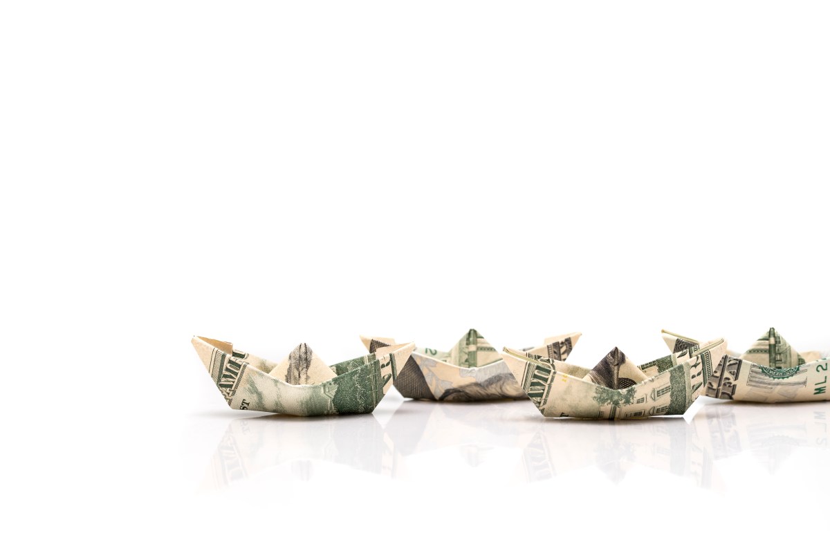 row of paper ships from dollar banknotes