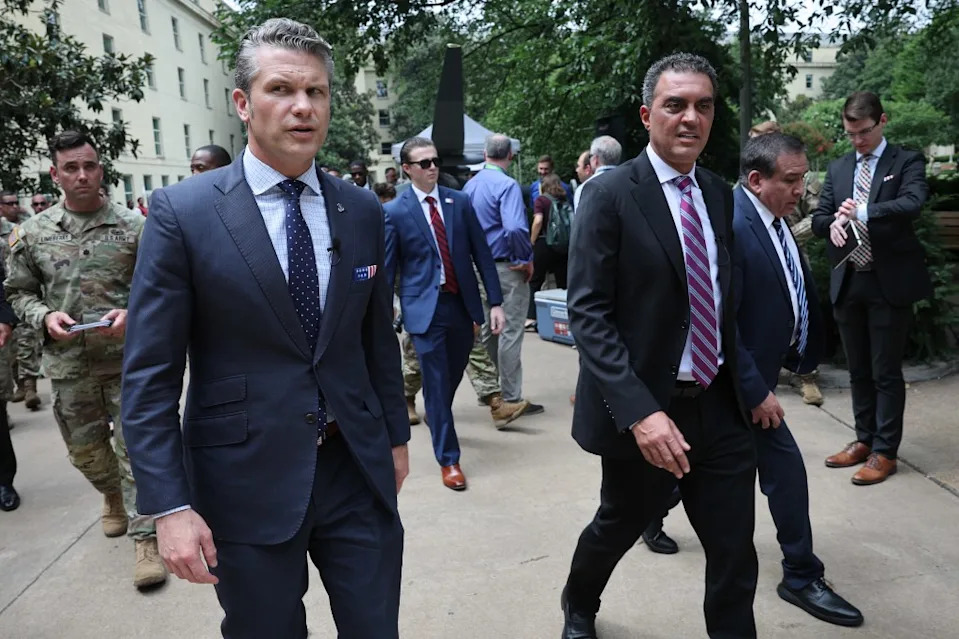 Pete Hegseth (left) and Emil Michael (right) walk together