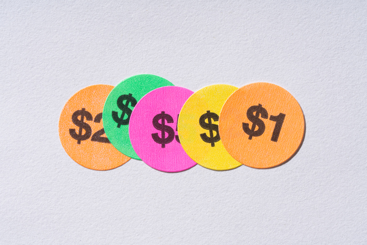 Multiple Covered Price Stickers Reducing Price to One Dollar on White Background Directly Above View.