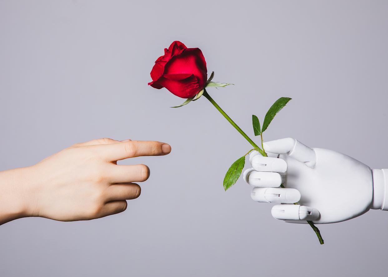A robot hand hands a rose to a human hand