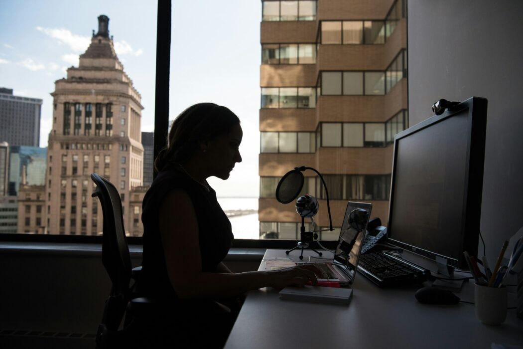 A woman sits in front of her computer.