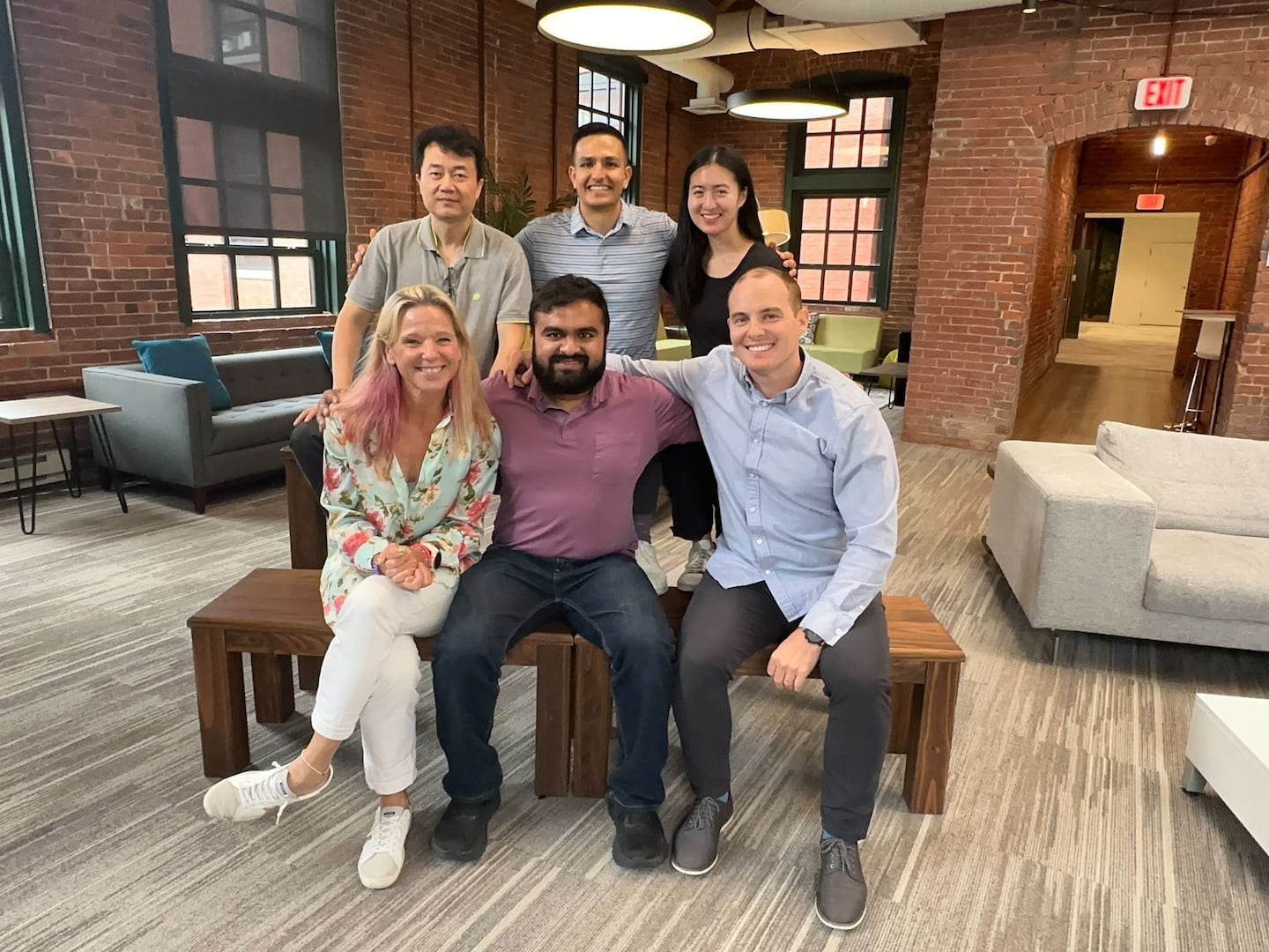 Blitzy chief executive Brian Elliott (bottom right) and chief technology officer Sid Pardeshi (bottom middle) with other employees of the Cambridge AI startup. The company, which helps businesses revamp antiquated software, raised $200 million at a valuation of $1.4 billion.