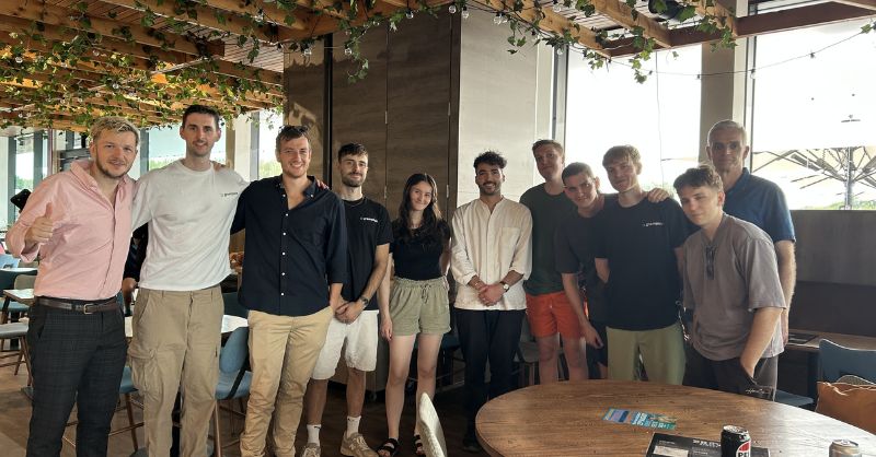 A group of people stand together smiling at the camera