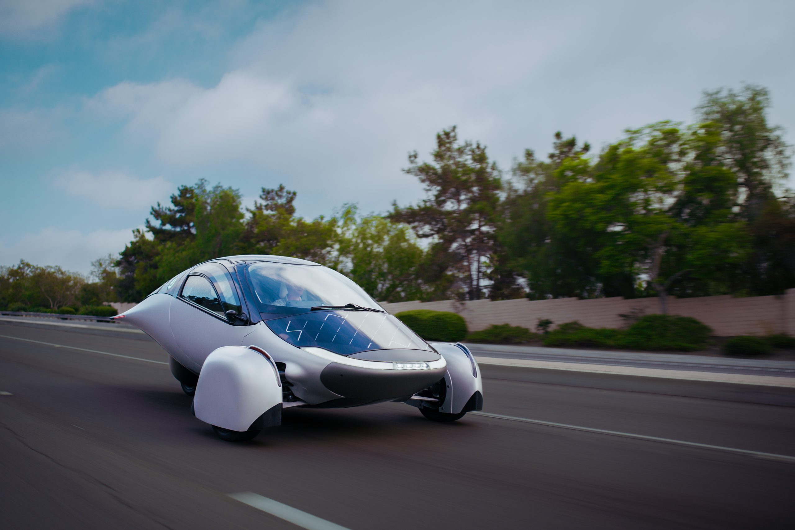 A futuristic, aerodynamic vehicle design with a sleek silver body and distinctive wheel coverings.
