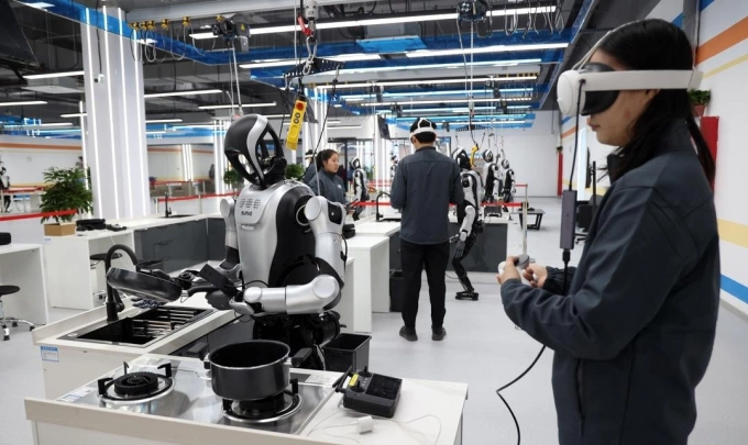Employees of a Chinese robotics firm guide humanoid robots through task in kitchen environment. Photo from X