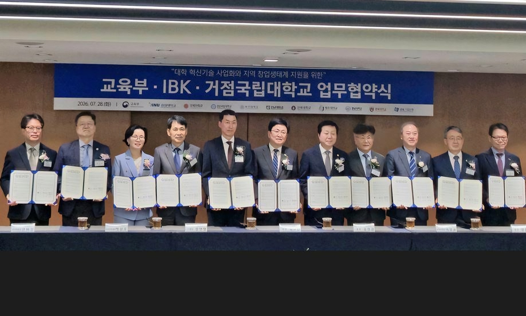 Education Minister Choi Kyo-jin, center, and IBK CEO Chang Min-young, fifth from left, pose with the presidents of nine regional national universities after signing a partnership agreement at IBK’s headquarters in Seoul on Tuesday. Kim Jeong-kyoum, fifth from right, is the president of Chungnam National University. Courtesy of Chungnam National University