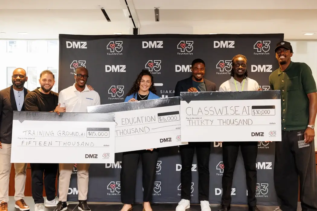 Prize winners pose with large checks.