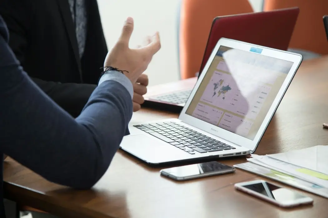 A laptop on a desk as a meeting takes place