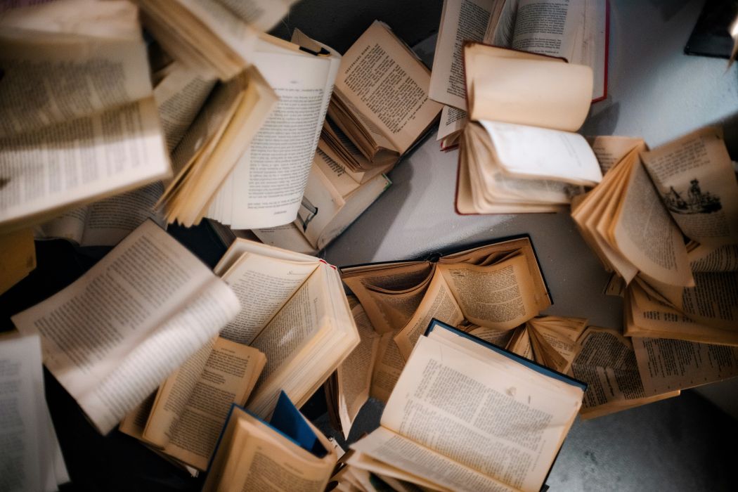 An image of dozens of open books falling over eachother