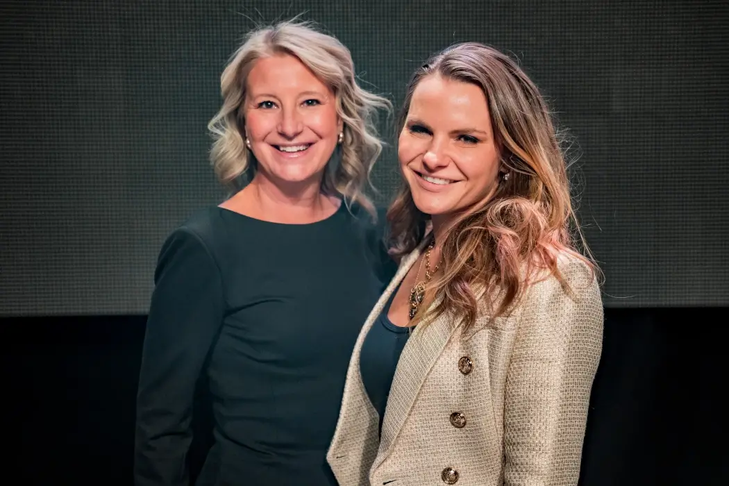 Two woman stand side by side smiling