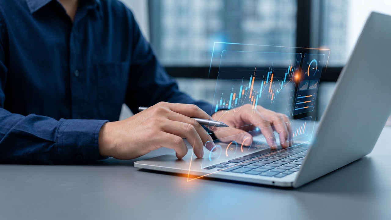 Person using a laptop with digital financial charts and data displayed on screen